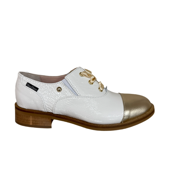 Cream patent leather loafer with a gold toe cap.